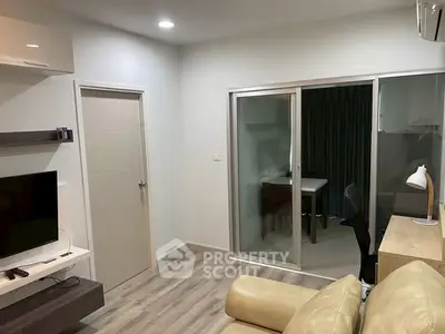 Modern living room with sleek design and sliding glass doors leading to a study area.