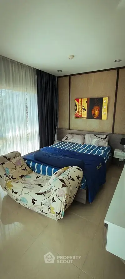 Modern bedroom with stylish decor and large windows offering natural light.