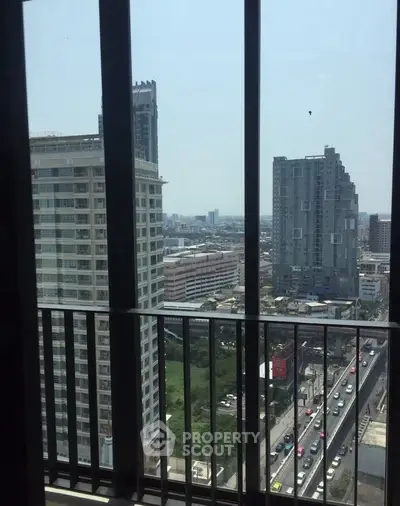 Stunning urban view from high-rise balcony overlooking city skyline and bustling streets.