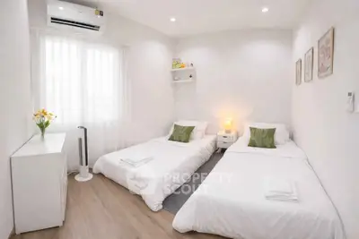 Cozy twin bedroom with modern decor and natural light