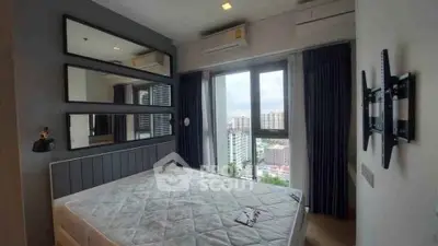 Modern bedroom with large windows and city view, featuring sleek design and ample natural light.