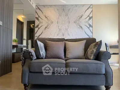 Stylish living room with elegant sofa and marble accent wall, perfect for modern living.