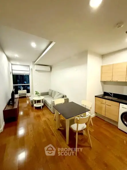 Modern living room with open kitchen and wooden flooring