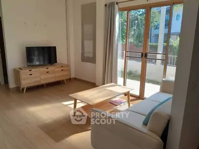 Bright living room with modern furniture and large sliding glass doors to balcony.