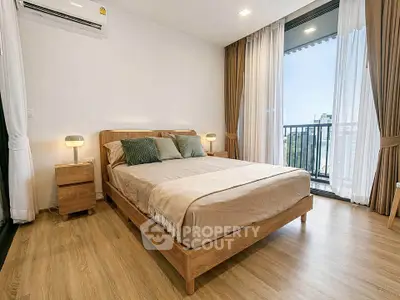 Modern bedroom with wooden flooring, large window, and stylish decor in a high-rise apartment.