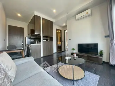 Modern living room with sleek furniture and open kitchen in a stylish apartment.