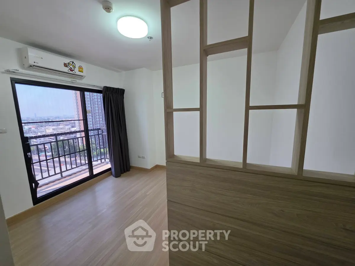 Modern apartment with balcony and city view, featuring sleek wooden partition and air conditioning.