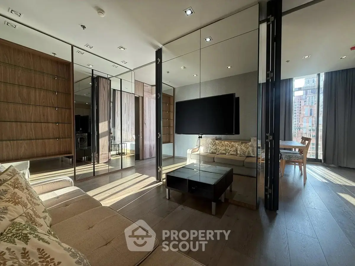 Luxurious modern living room with mirrored walls and elegant furnishings in a high-rise apartment.