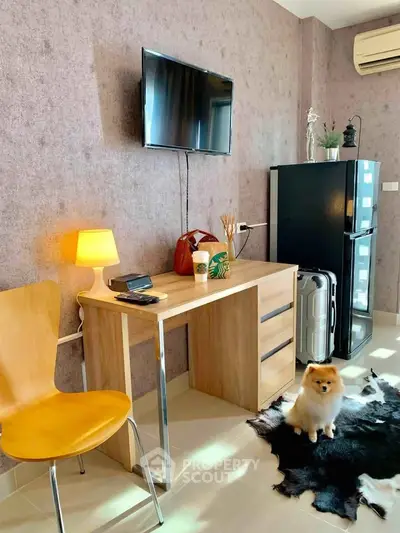 Modern study room with desk, chair, TV, and mini fridge, featuring stylish decor and a cozy atmosphere.