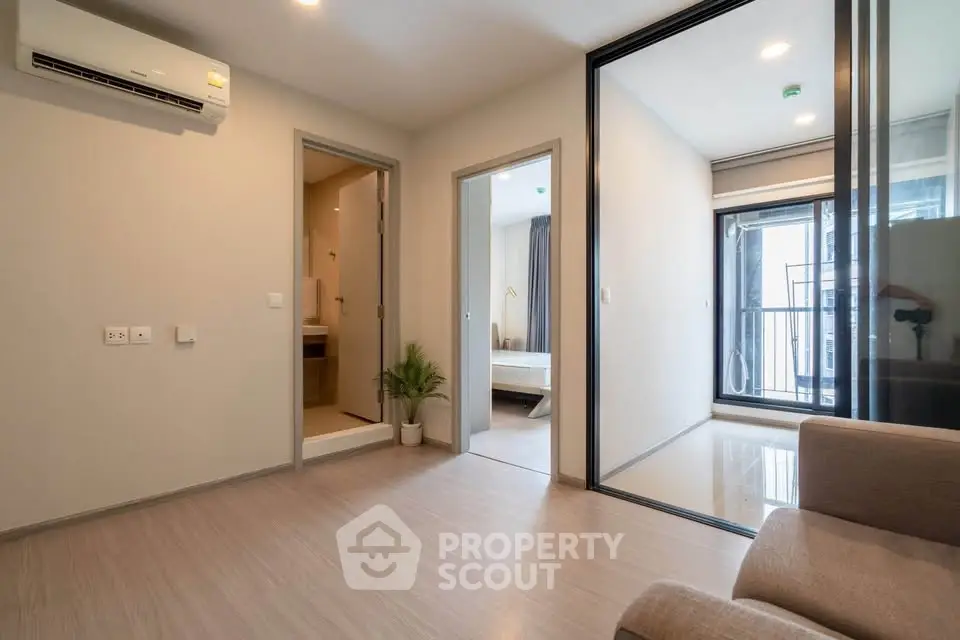 Modern apartment interior with open layout, featuring a cozy living area and visible bedroom.