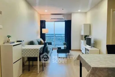 Modern living room with balcony view, stylish furniture, and natural light.