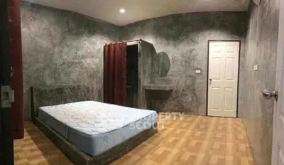 Modern minimalist bedroom with concrete walls and wooden flooring