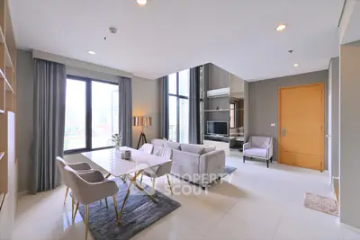 Spacious modern living room with elegant decor and large windows offering city views.