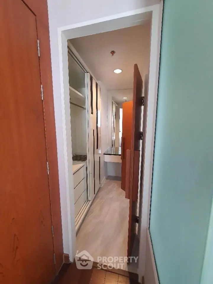Modern hallway with sleek storage and wooden doors in a contemporary apartment.