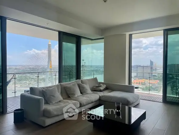 Luxurious living room with stunning city view and spacious balcony in modern high-rise apartment.
