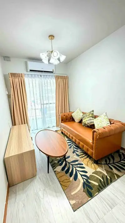 Chic living room with modern decor, featuring a stylish leather sofa and elegant lighting.