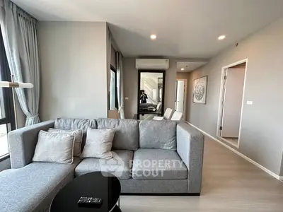 Modern living room with gray sectional sofa and stylish decor in a bright apartment.