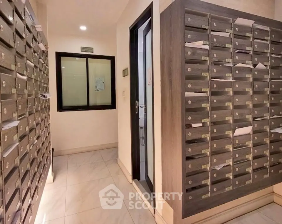 Modern apartment building mailroom with organized mailboxes and sleek design.