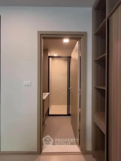 Modern bathroom entrance with sleek wooden shelving and minimalist design