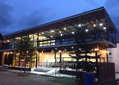 Modern two-story building with illuminated exterior and open design, perfect for commercial or residential use.
