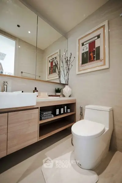 Modern bathroom with sleek fixtures and stylish decor, featuring a large mirror and elegant vanity.