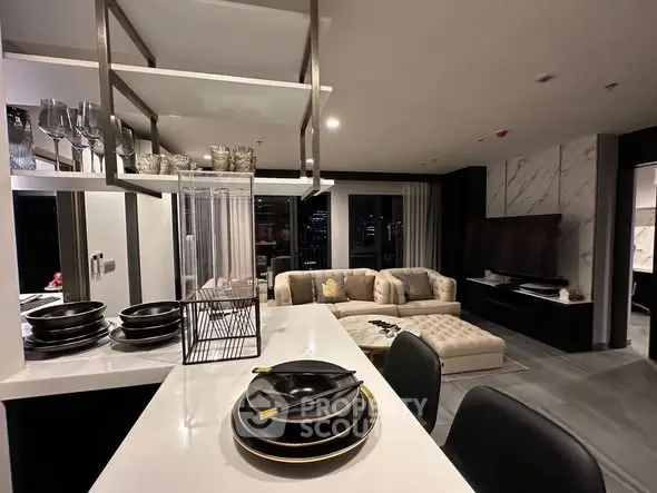Luxurious modern living room with open kitchen, elegant decor, and city view.
