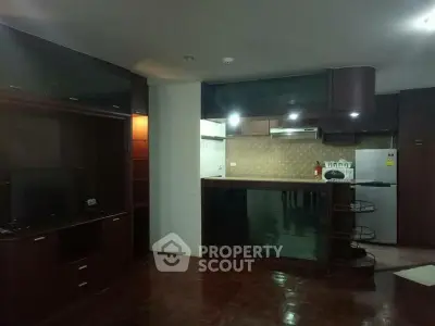 Spacious open-layout kitchen with modern appliances and dark wood cabinetry.