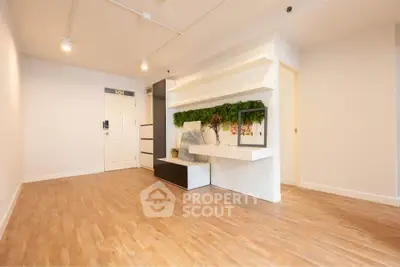 Spacious modern living room with wooden flooring and stylish built-in shelves.