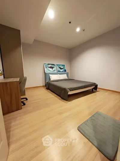 Spacious bedroom with modern decor and wooden flooring, perfect for relaxation and comfort.