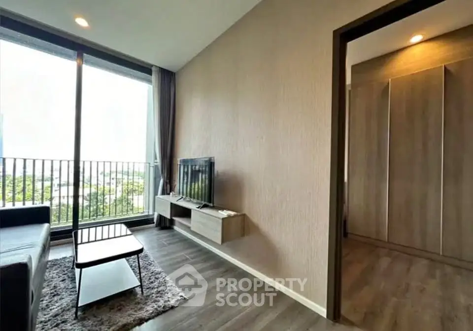 Modern living room with large window and stylish decor in a high-rise apartment.