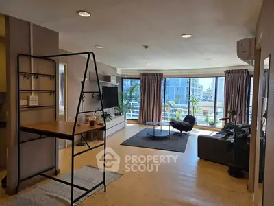 Spacious living room with large windows and modern decor, offering a bright and inviting atmosphere.