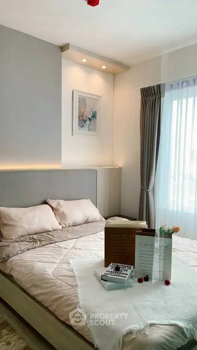 Luxurious bedroom with elegant decor and natural light from large window.