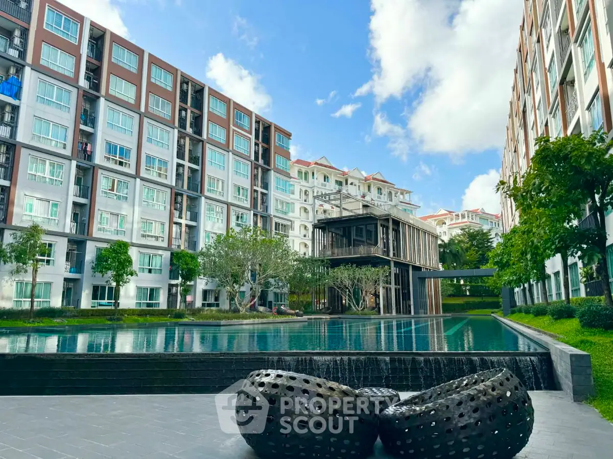 Modern apartment complex with pool and lush greenery, offering serene urban living.
