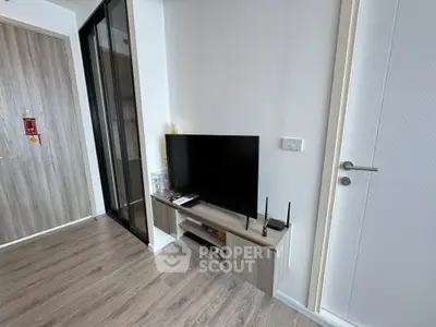 Modern living room with sleek TV setup and wooden flooring