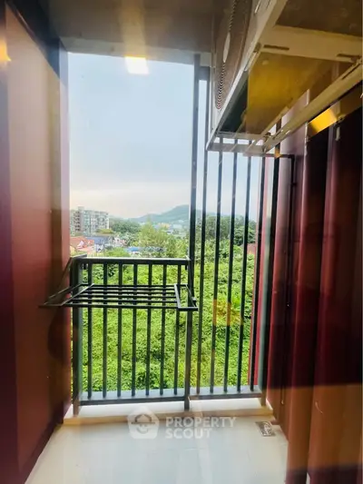 Charming balcony with scenic view of lush greenery and distant hills, perfect for relaxation.