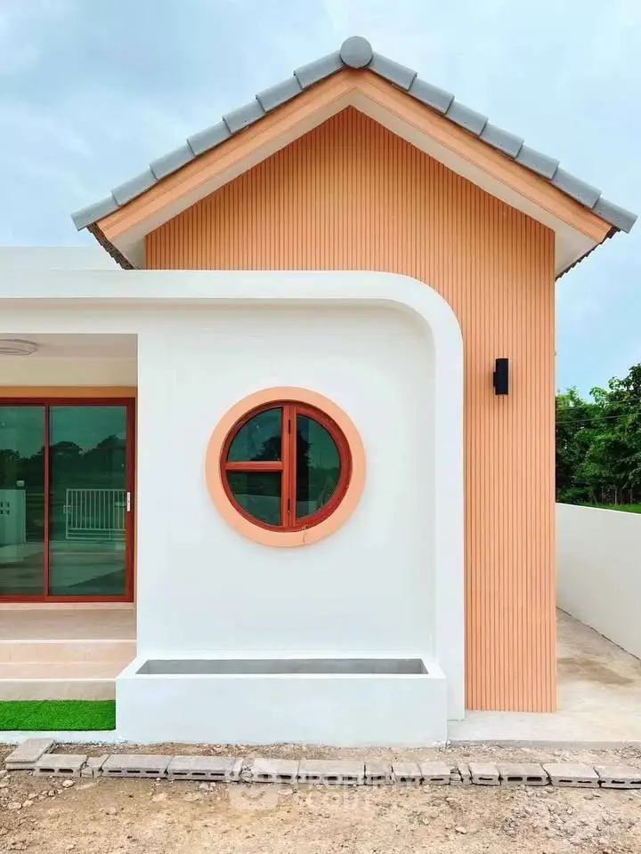 Charming modern house exterior with unique circular window and stylish design.