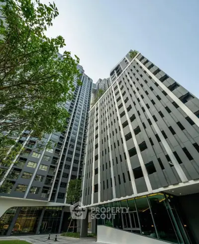 Modern high-rise building with sleek architecture and lush greenery