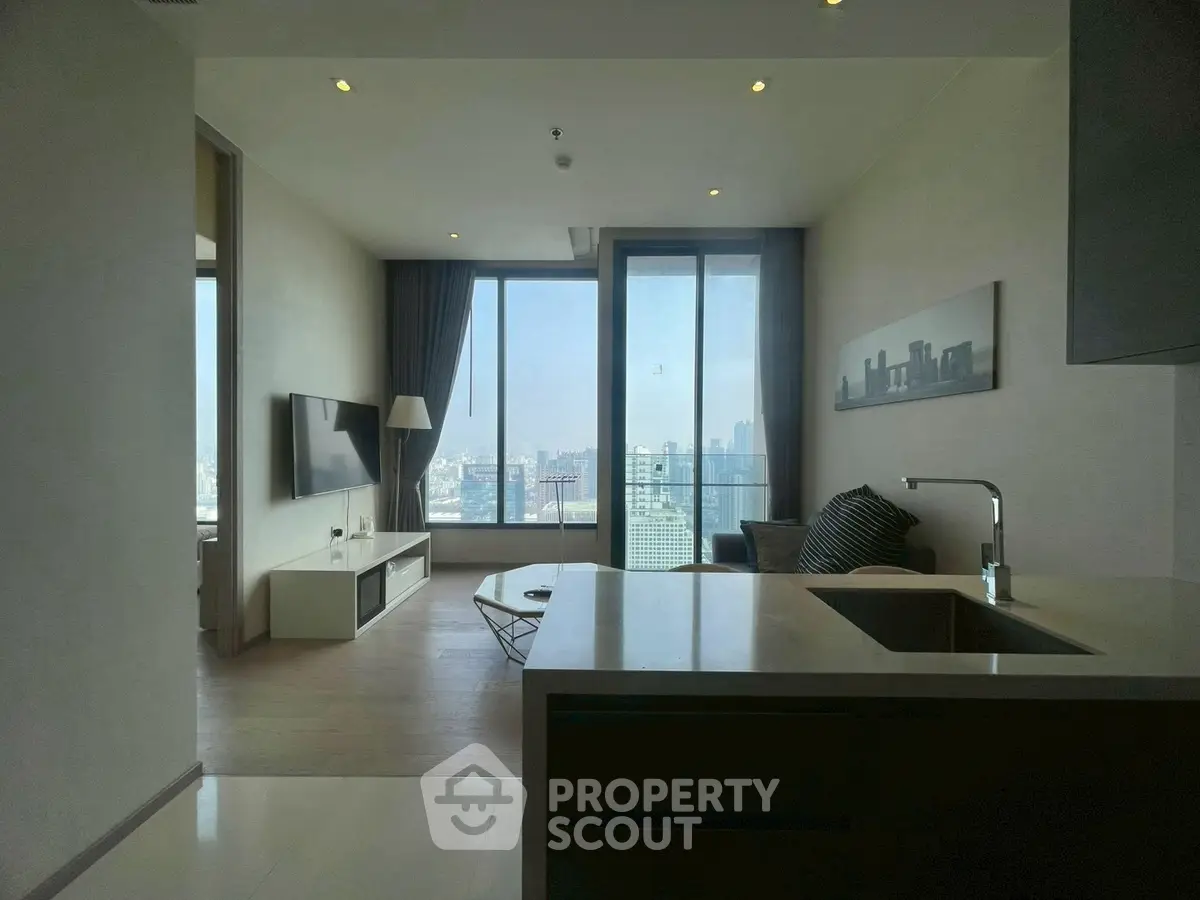 Modern living room with city view, open layout, and sleek furnishings in a high-rise apartment.