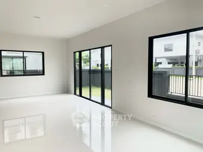 Spacious modern living room with large windows and garden view