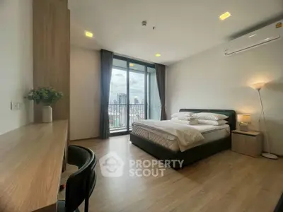Spacious bedroom with city view and modern furnishings in a high-rise apartment.