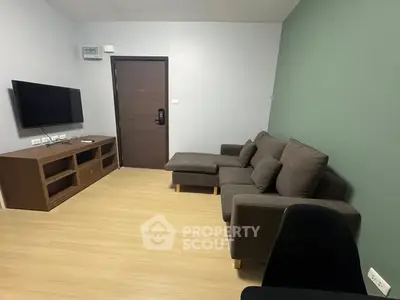 Modern living room with stylish sofa and wall-mounted TV in a cozy apartment.