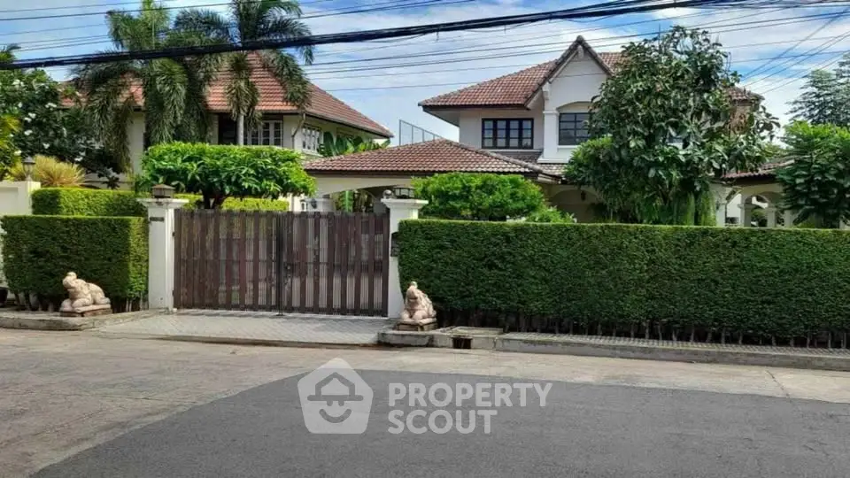 Charming suburban house with lush greenery and gated entrance, perfect for family living.