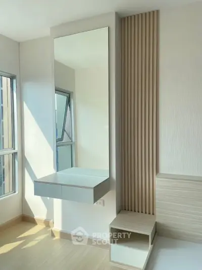 Modern bedroom with sleek built-in vanity and large windows for natural light.