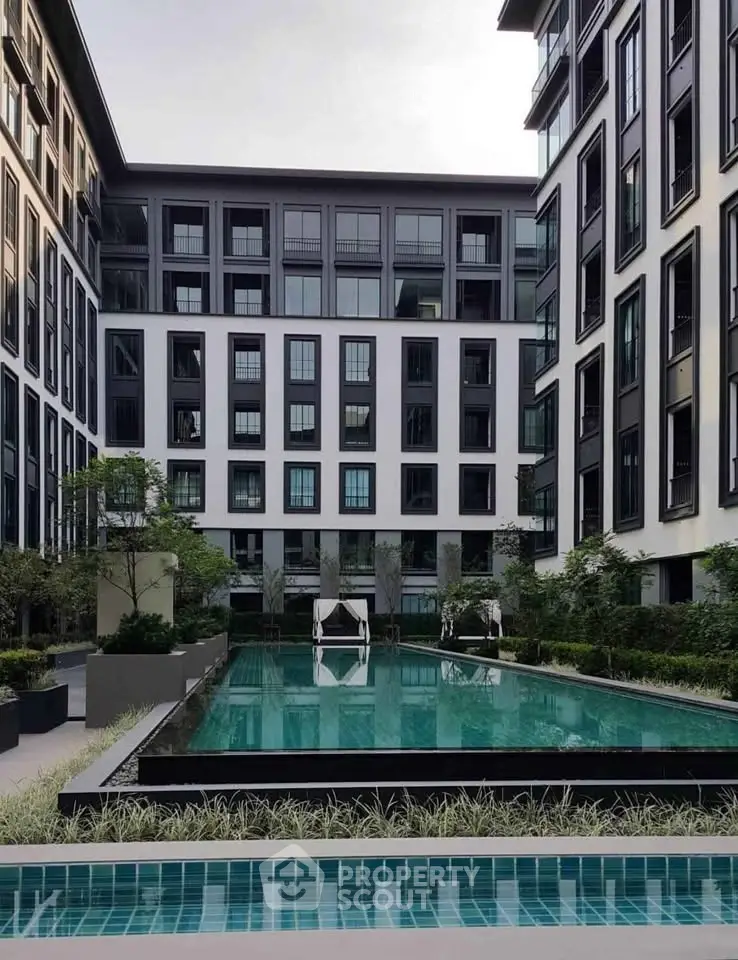 Modern apartment complex with a luxurious swimming pool and stylish architecture.