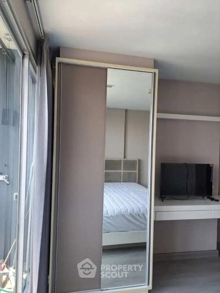 Modern bedroom with mirrored wardrobe and sleek TV setup