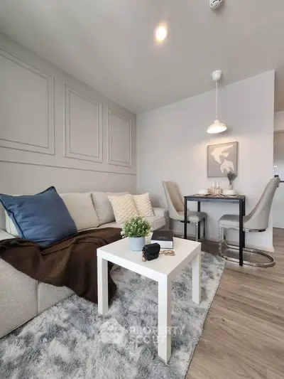 Modern living room with cozy sofa, stylish decor, and elegant dining area in open layout.