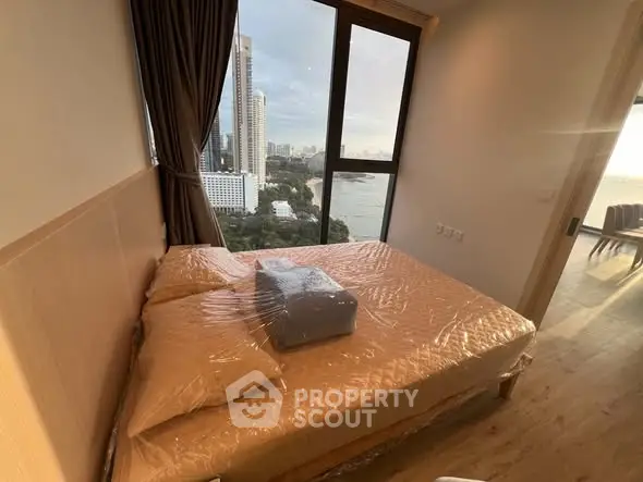 Modern bedroom with stunning city view and large window, featuring cozy bed and elegant decor.