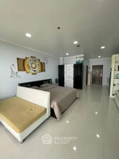 Spacious modern bedroom with sleek design and ample natural light, featuring stylish decor and comfortable furnishings.