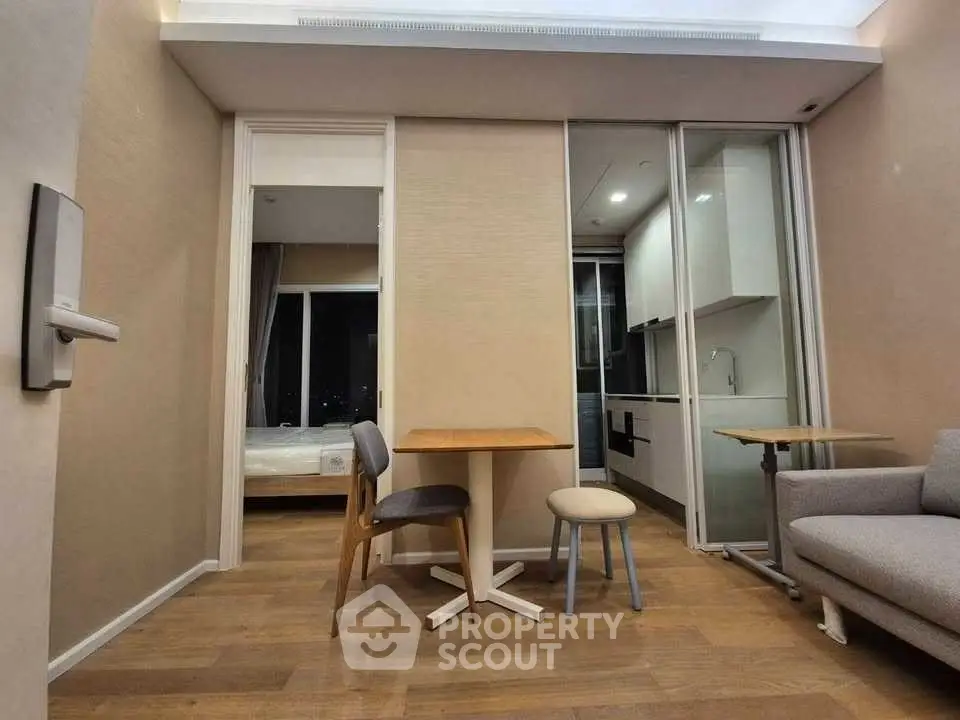Modern apartment interior with open layout, featuring cozy living area and compact kitchen.