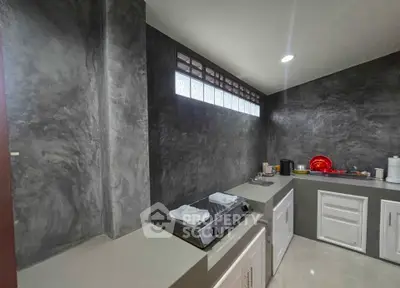 Modern kitchen with sleek countertops and built-in gas stove, featuring minimalist design and ample storage space.